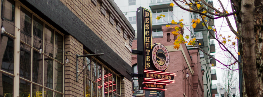 City street scene with a building exterior and neon sign.